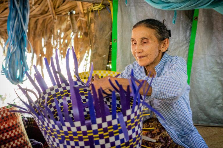 Older woman in Myanmar weaving a large, beautiful basket