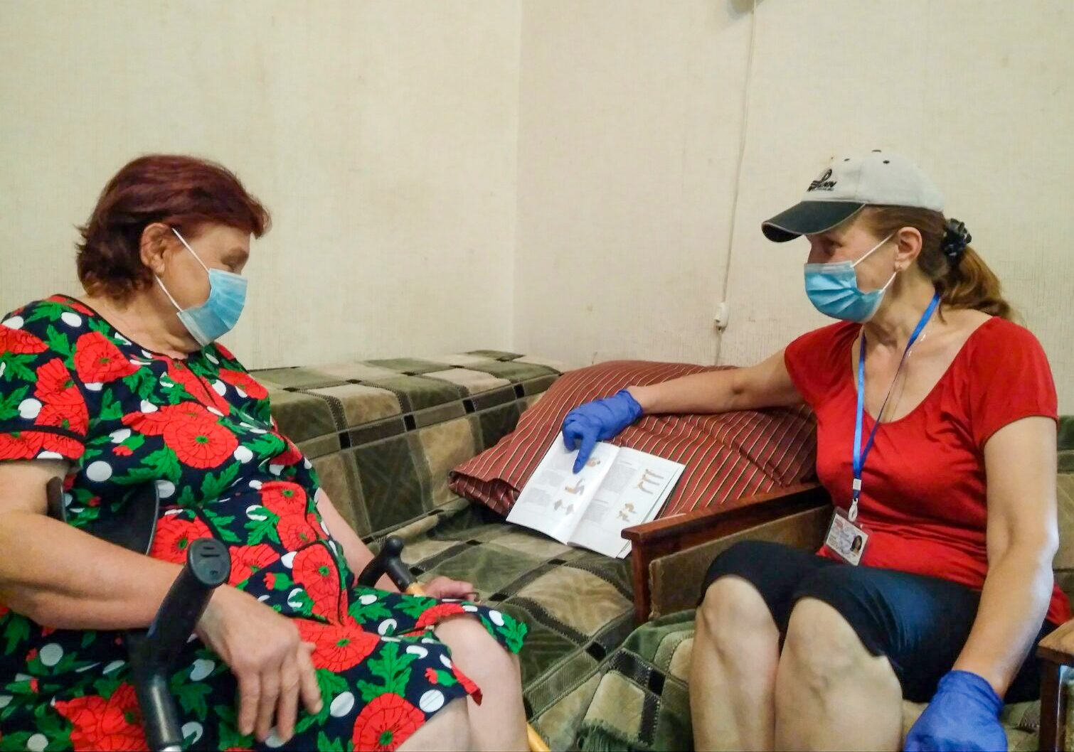 HelpAge volunteer reads to an older Ukrainian woman